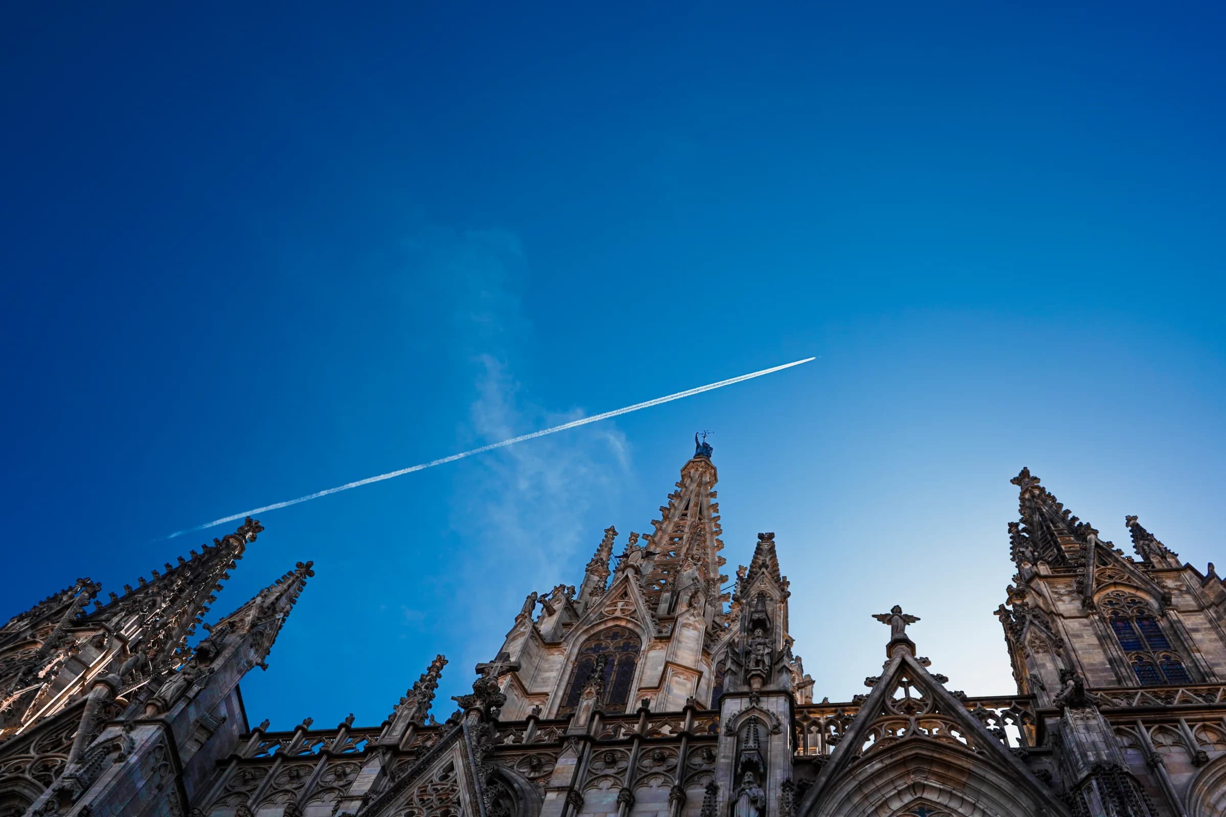 A cathedral facade rising into a deep blue Barcelona sky